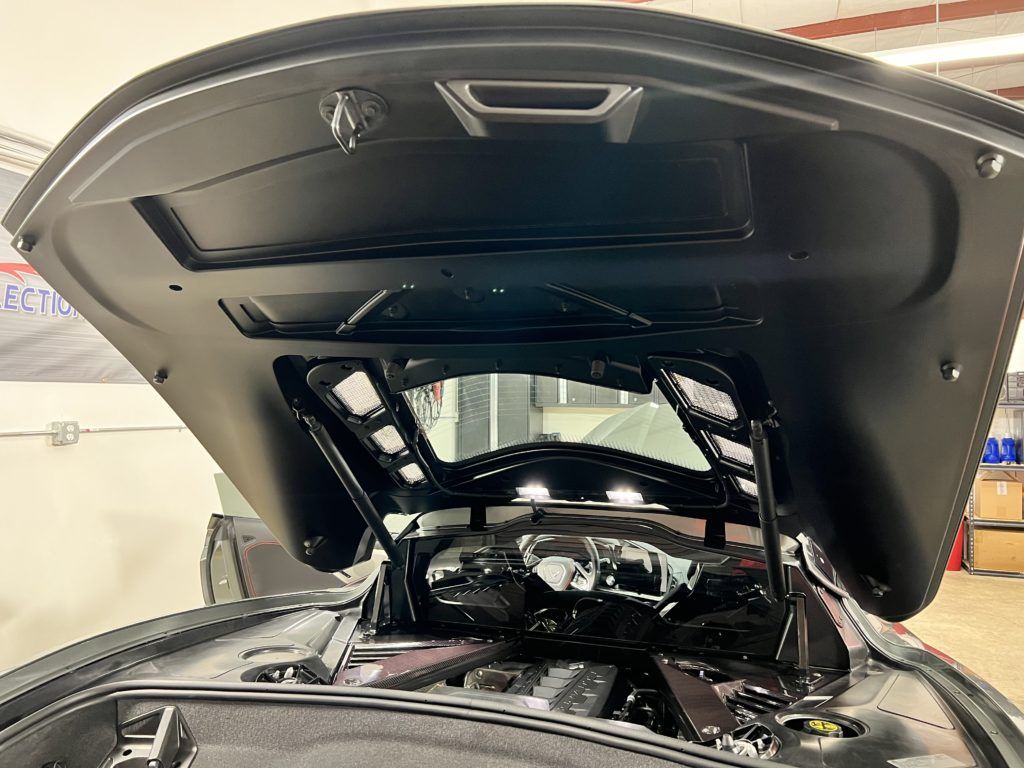 The hood of a car is open and the engine is visible.