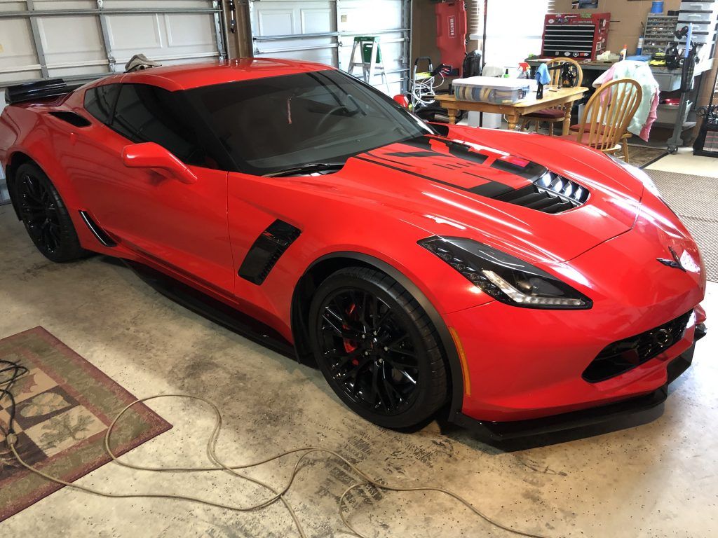 A red sports car is parked in a garage.