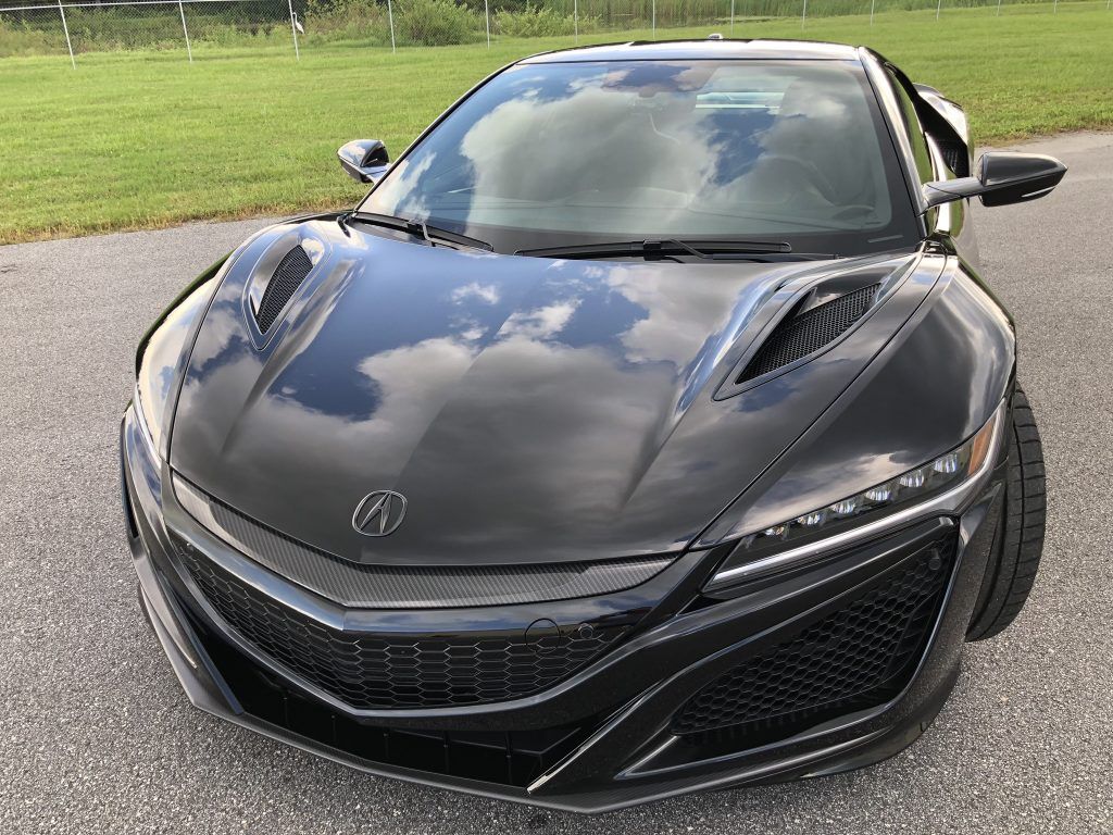 A black sports car is parked on the side of the road.