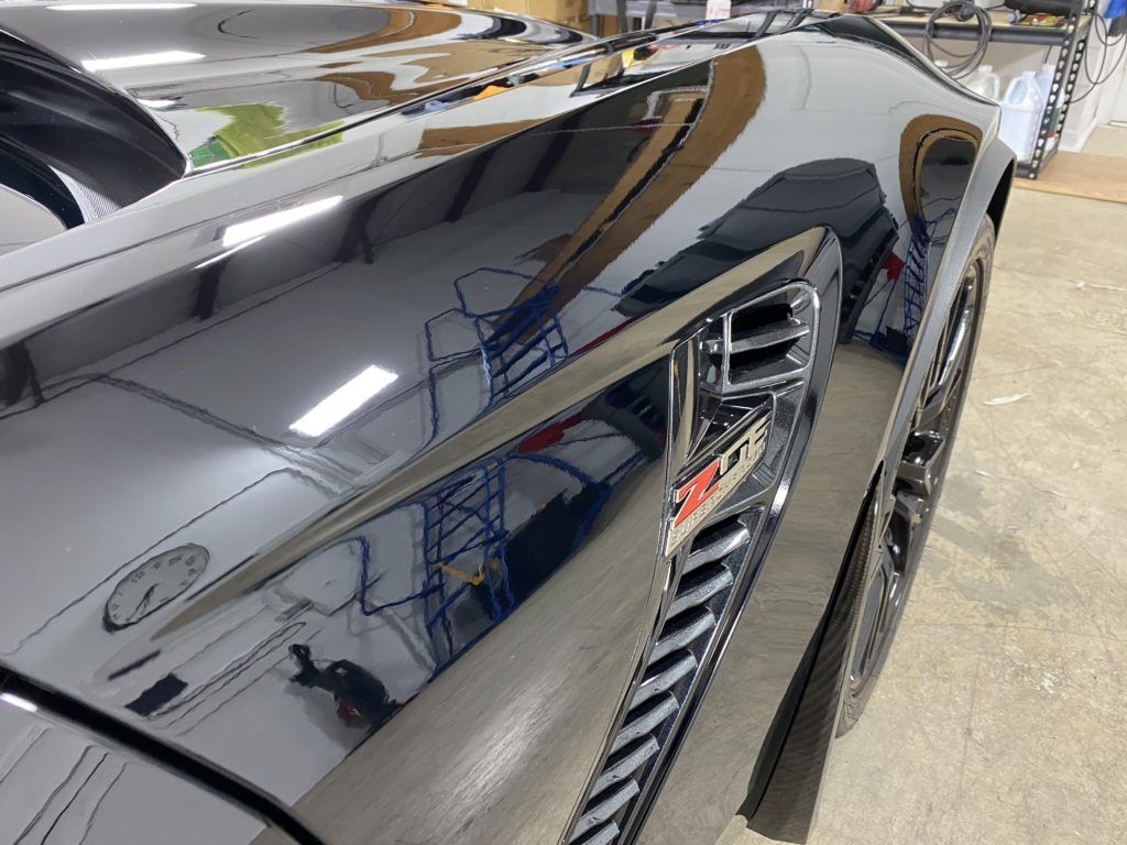 A close up of a car 's hood in a garage.