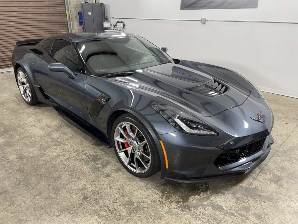 A gray corvette zr1 is parked in a garage.