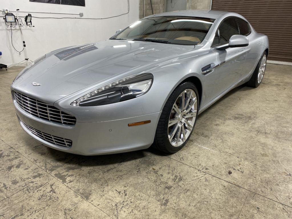 A silver sports car is parked in a garage.