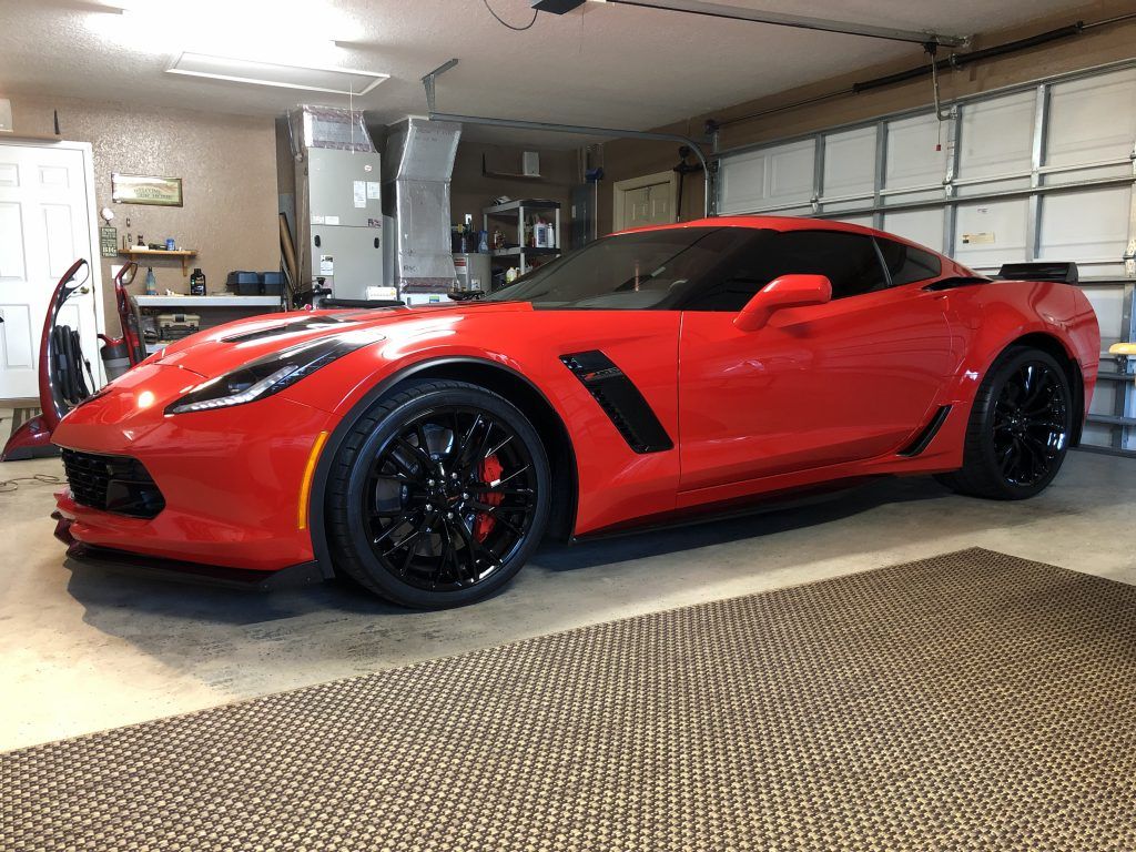 A red corvette zr1 is parked in a garage.