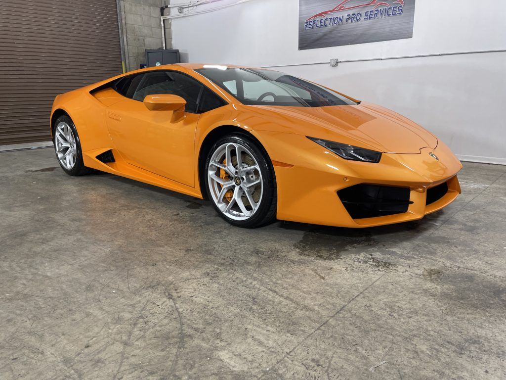 A yellow lamborghini huracan is parked in a garage.