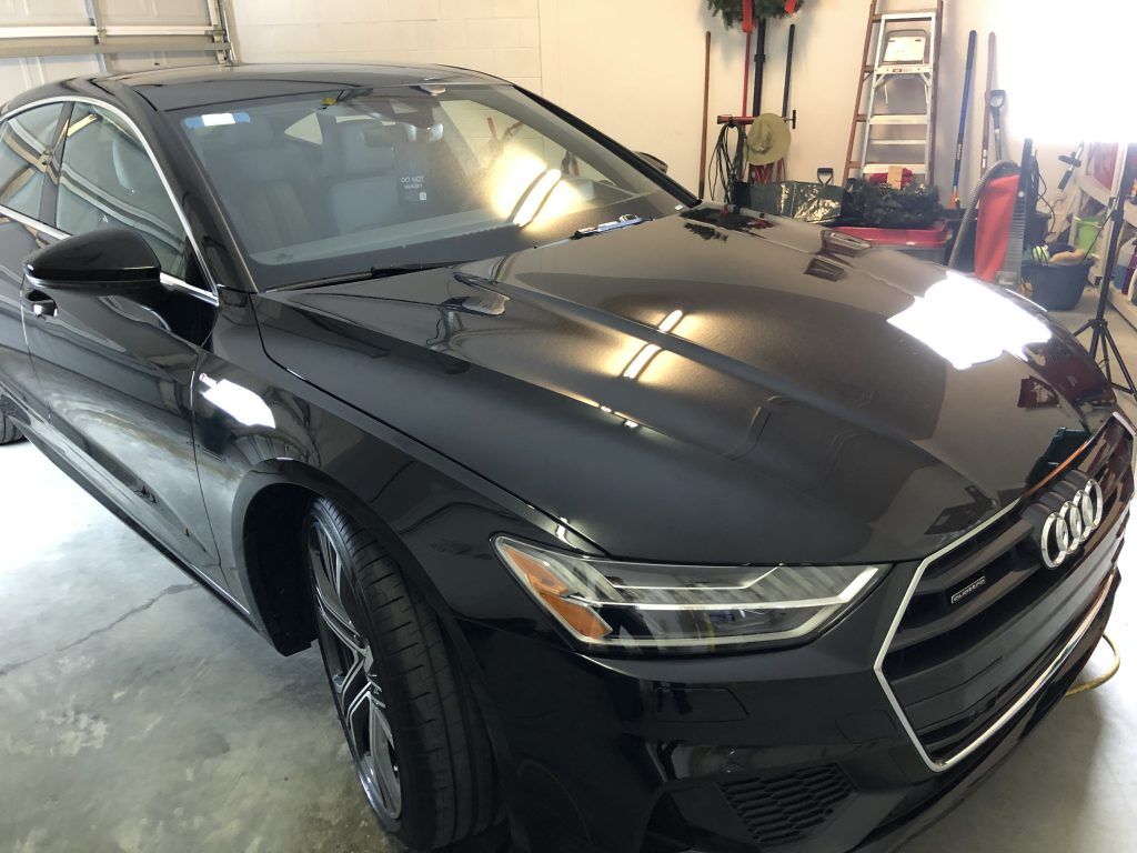 A black audi a7 is parked in a garage.