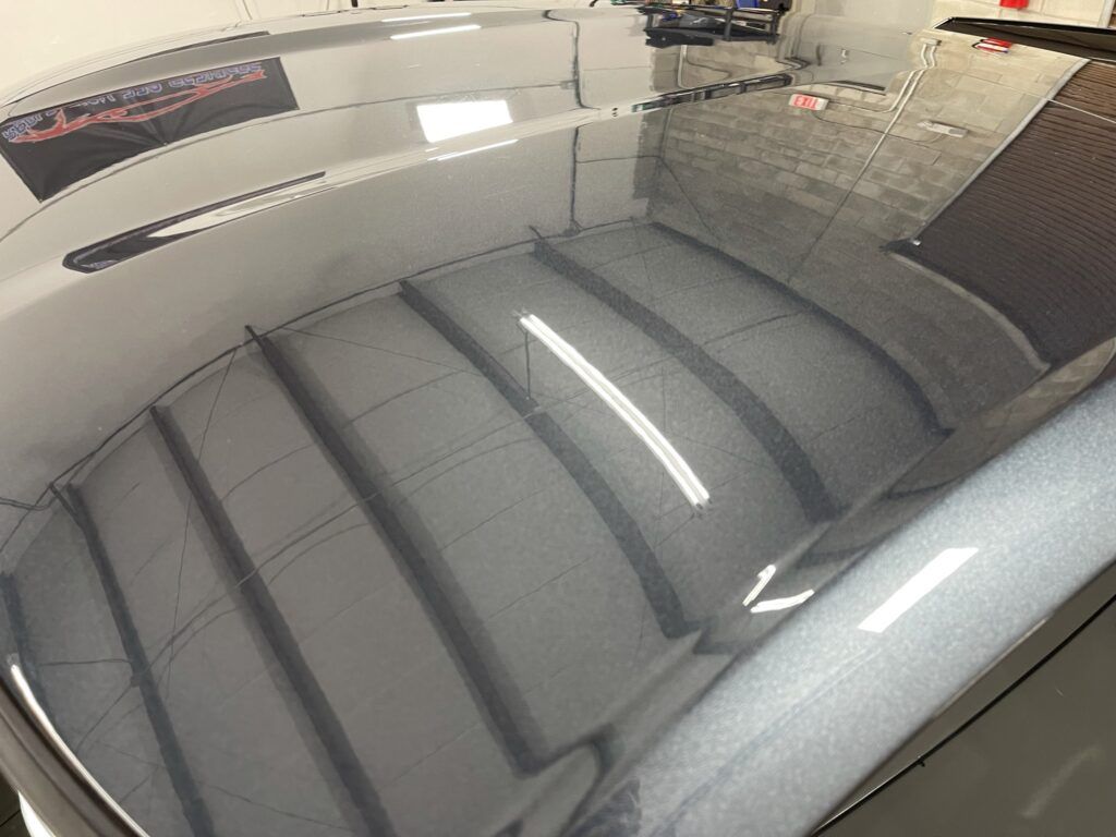 A close up of the hood of a car in a garage.