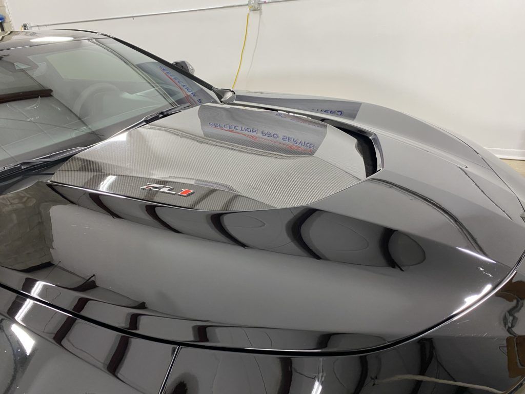 A close up of the hood of a car in a garage.