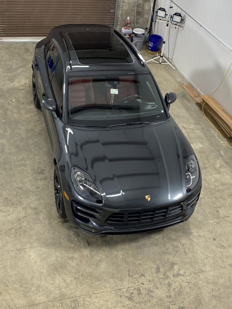 A black porsche macan turbo is parked in a garage.