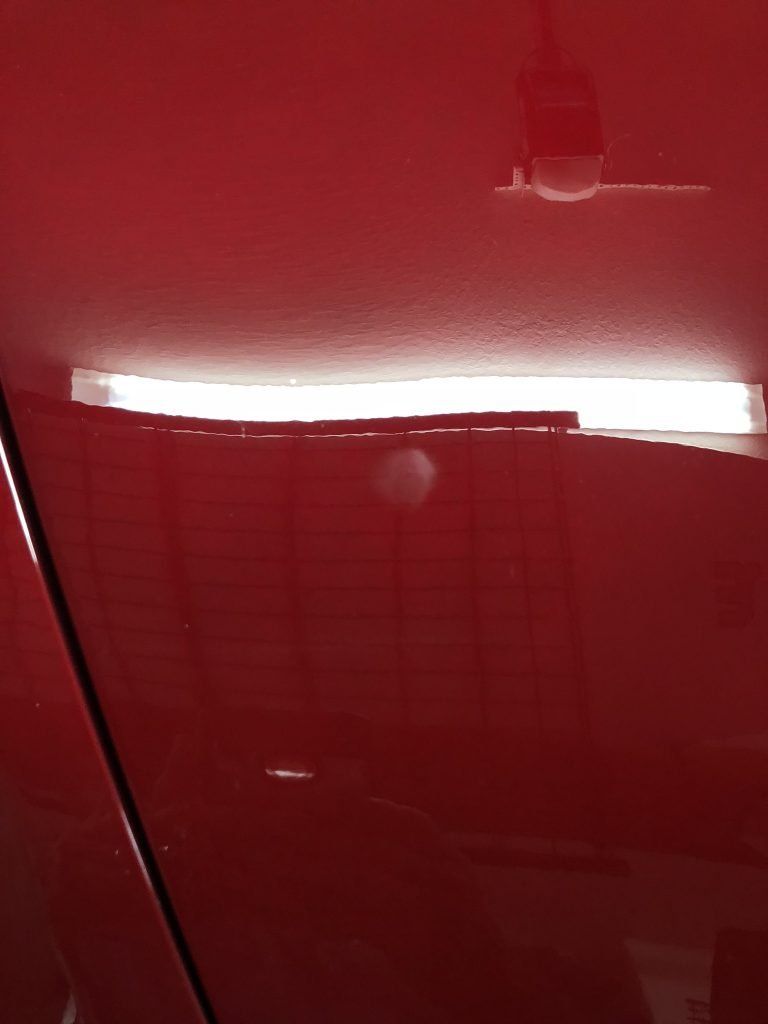 A red car with a light on the side of it