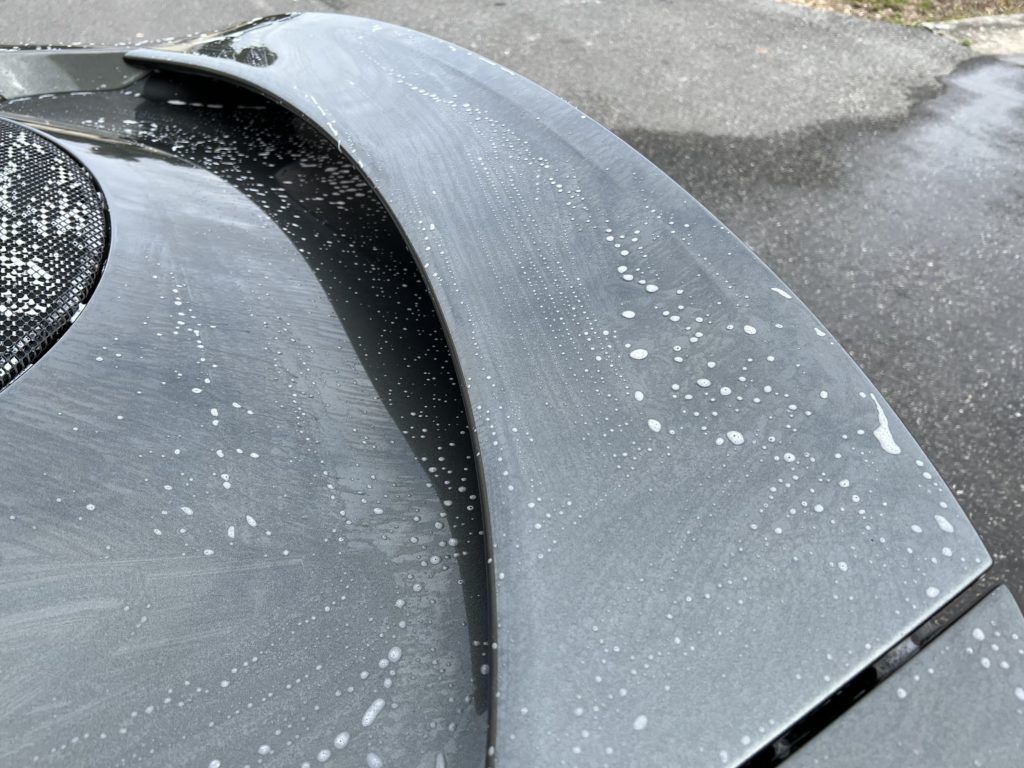 A close up of a car 's rear bumper with white spots on it