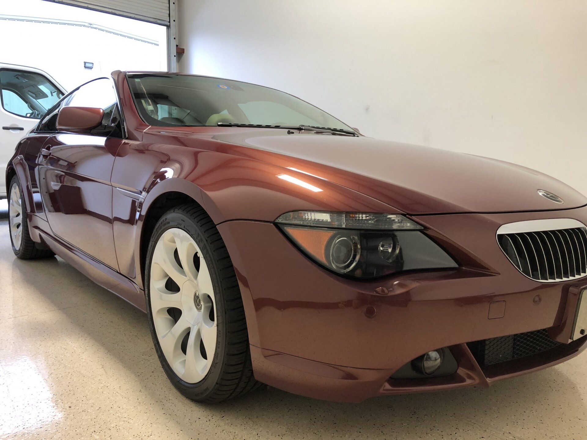 A red sports car is parked in a garage.
