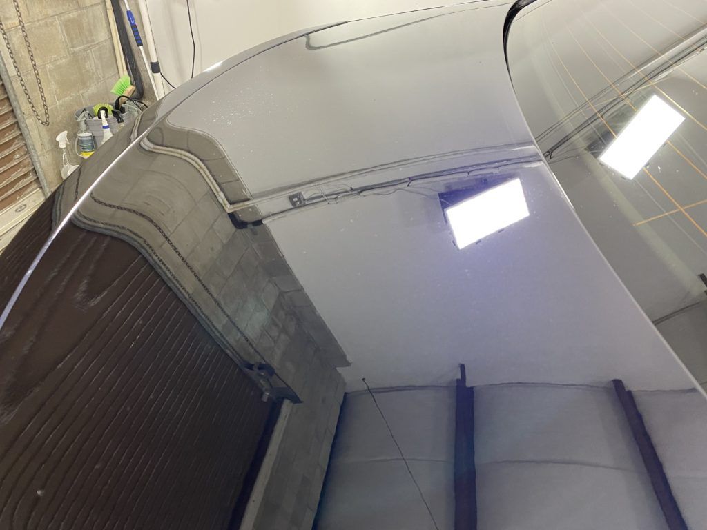 A ceiling with a light on it and a staircase in the background.