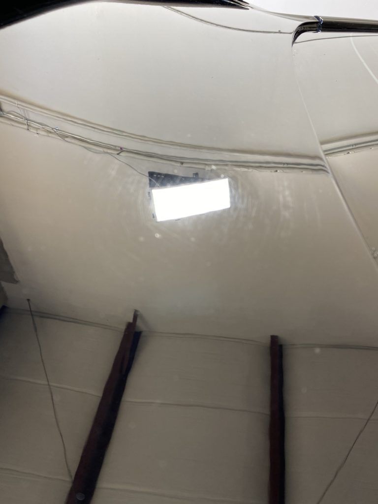 A close up of a ceiling with a light shining through it.