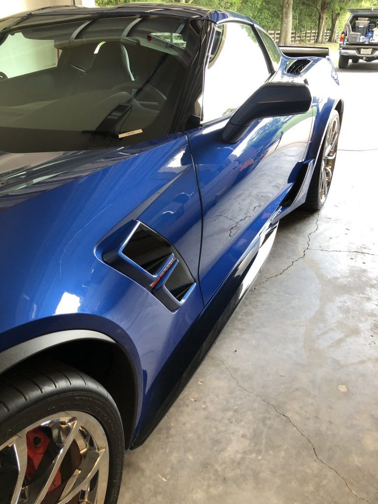 A blue sports car is parked in a garage.