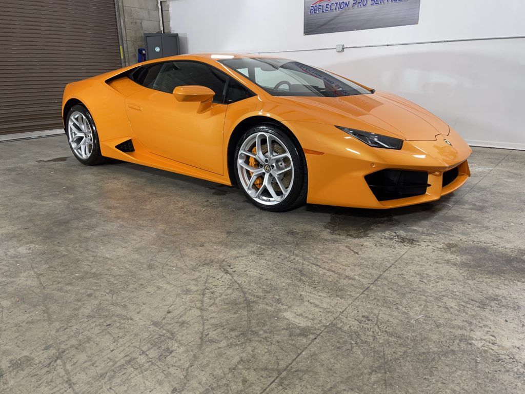 A yellow lamborghini huracan is parked in a garage.