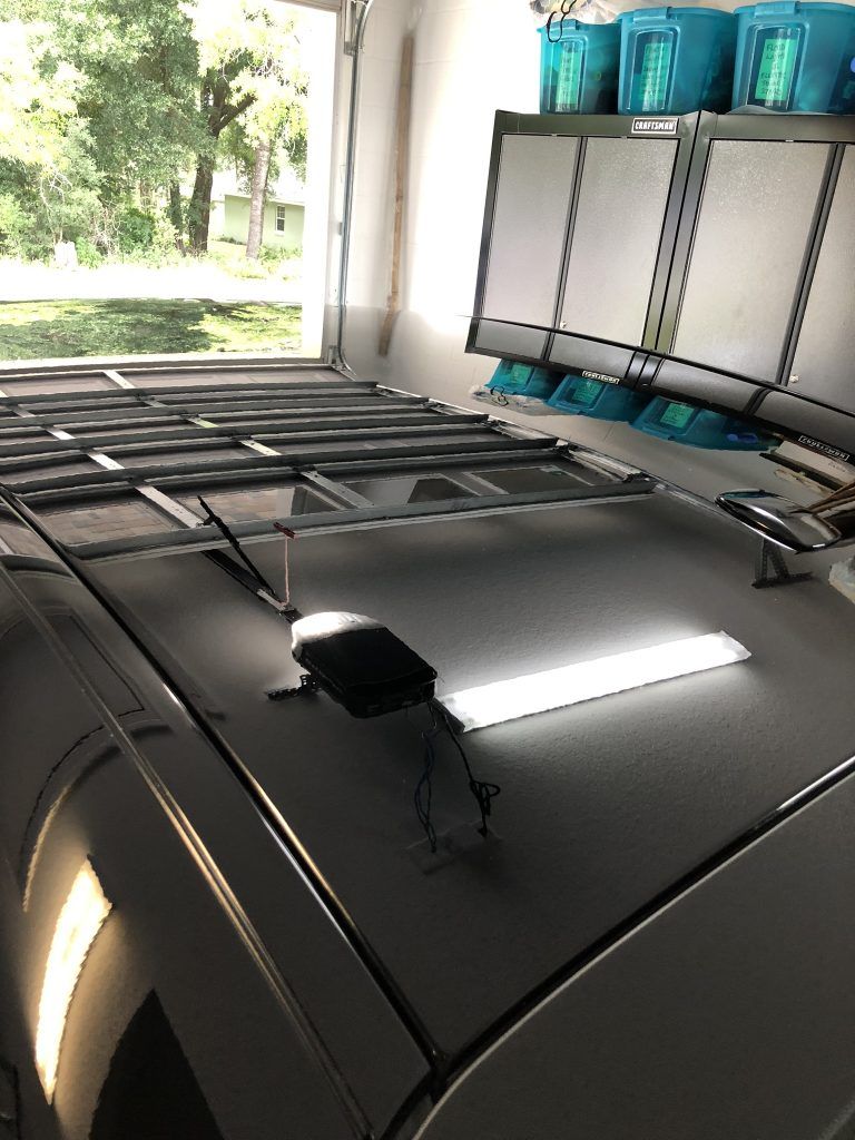 A roof rack is sitting on top of a car in a garage.