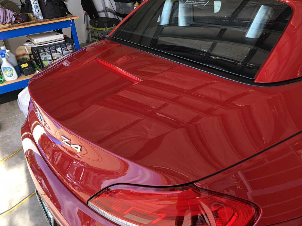 A red car is parked in a garage.