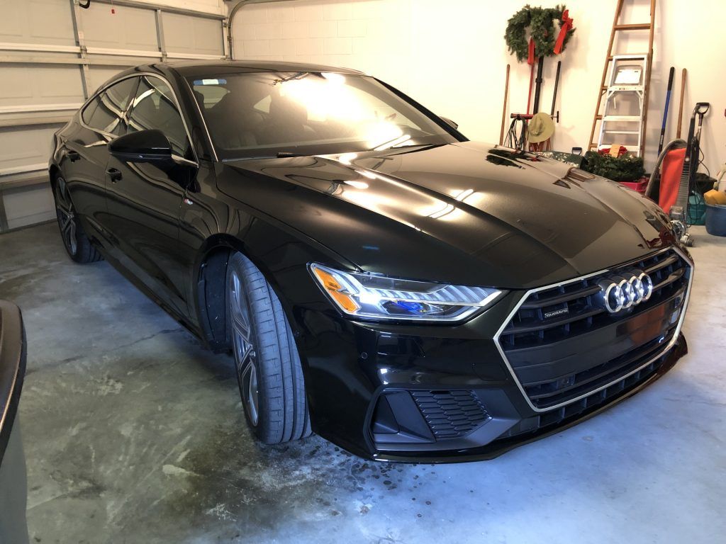 A black audi a7 is parked in a garage.