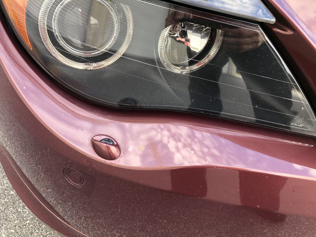 A close up of a car 's headlight and bumper