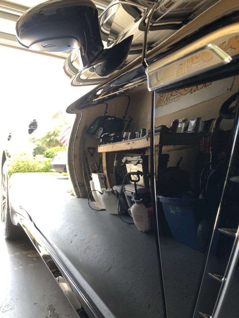 A car is parked in a garage with the door open.