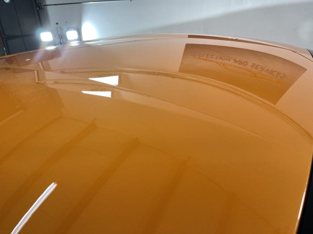 A close up of the hood of a car in a garage.