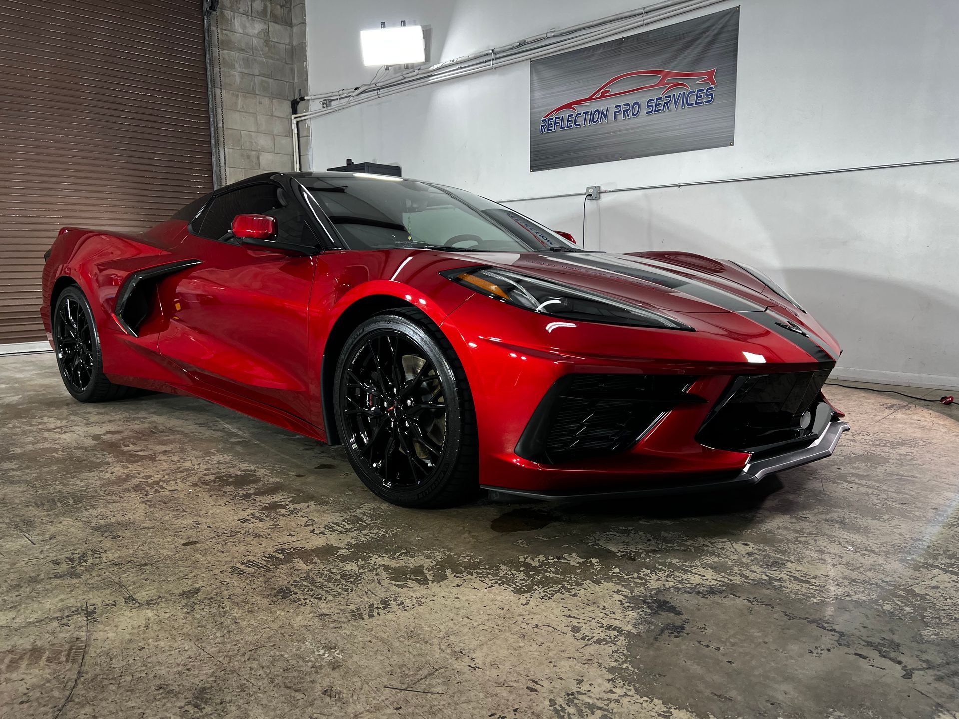 A red sports car is parked in a garage.
