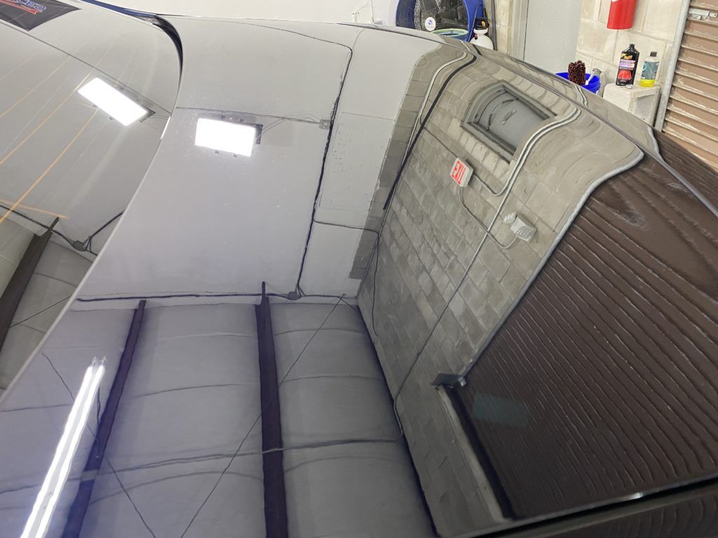 A close up of a car 's windshield in a garage.