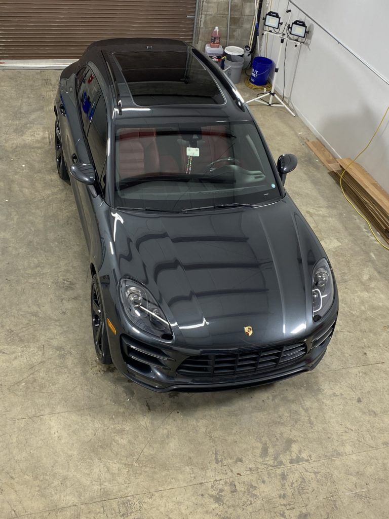 A black porsche macan turbo is parked in a garage.
