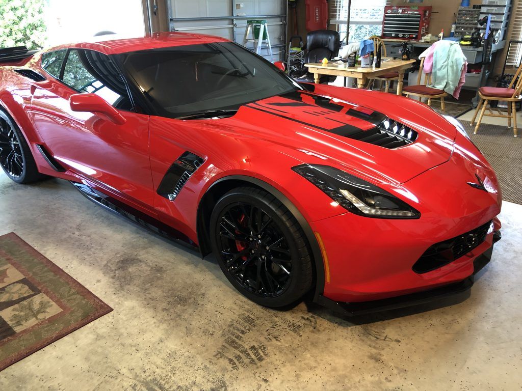 A red sports car is parked in a garage.