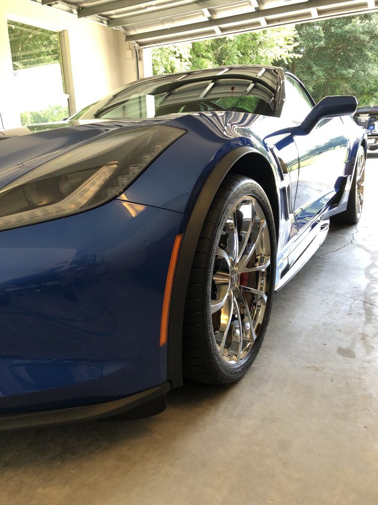 A blue sports car is parked in a garage.