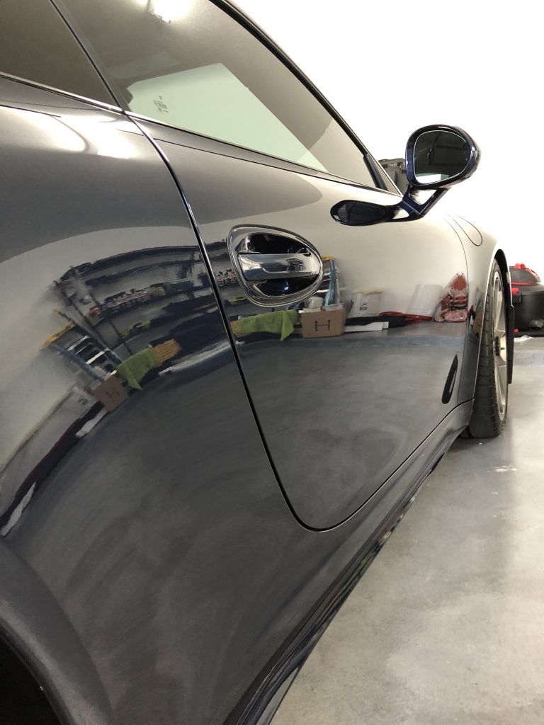 A black sports car is parked in a garage.