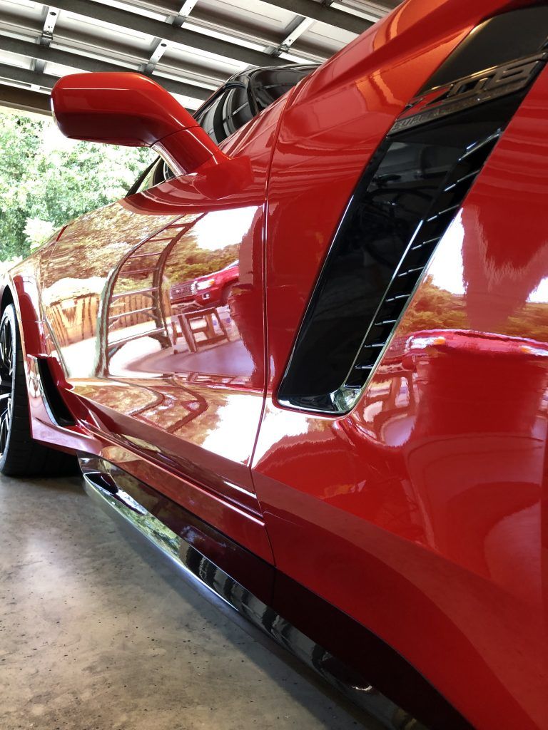 A red sports car is parked in a garage.