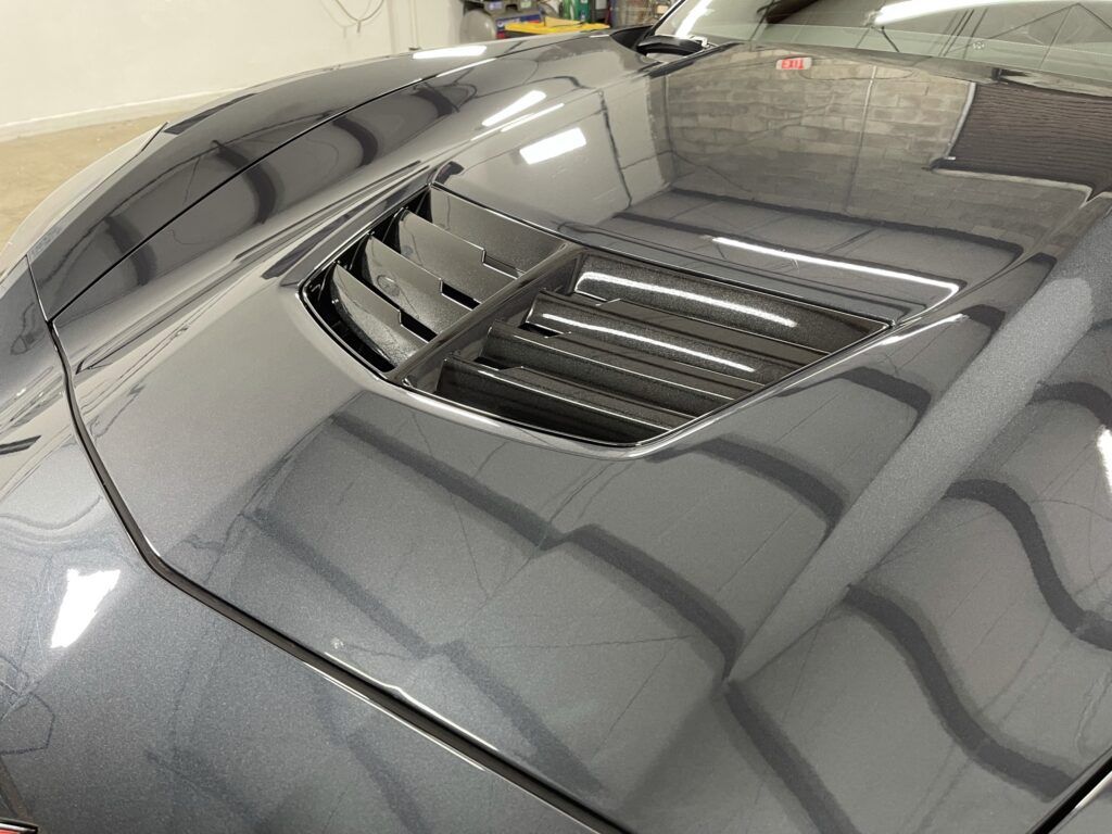 A close up of the hood of a car in a garage.