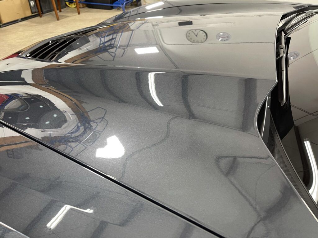 A close up of the hood of a car in a garage.