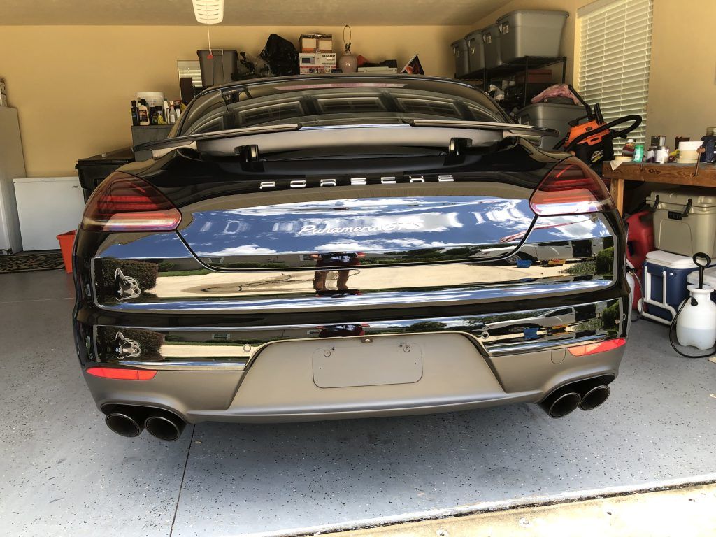 A black sports car is parked in a garage.