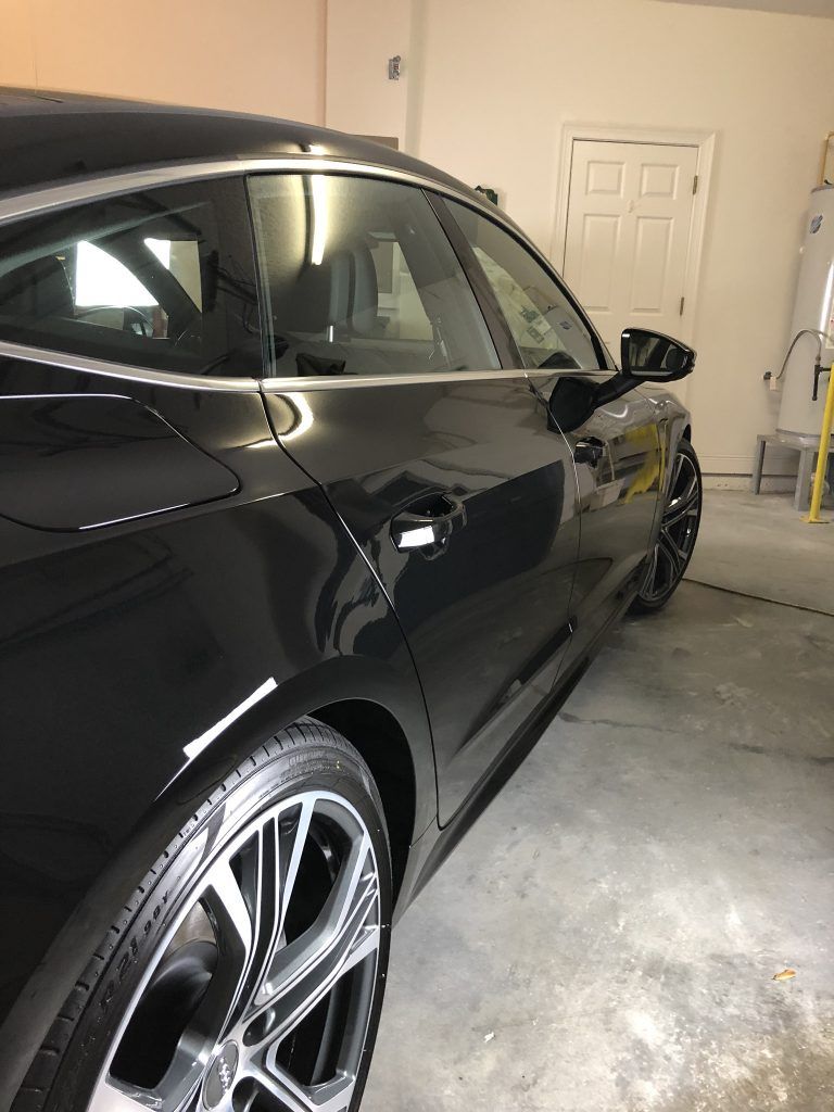 A black car is parked in a garage.