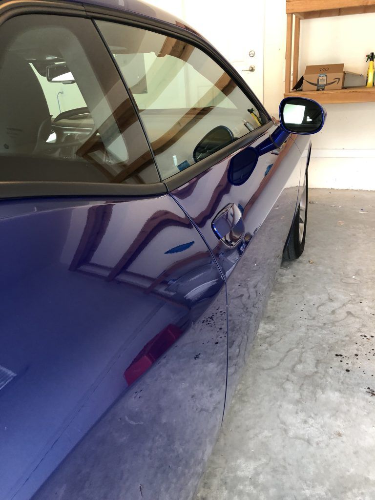 A blue sports car is parked in a garage