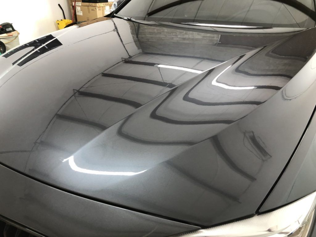 A close up of the hood of a car in a garage.
