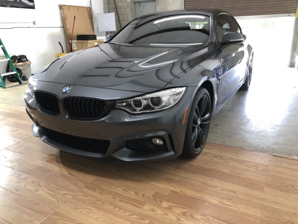 A bmw 4 series convertible is parked in a garage.