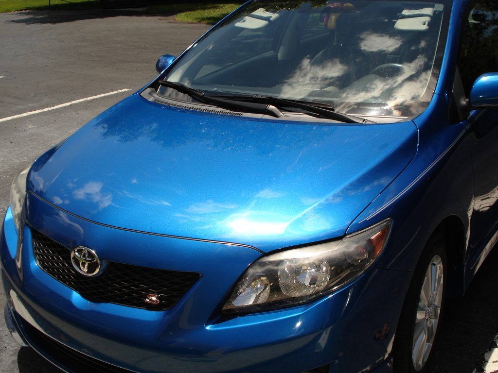A blue toyota car is parked in a parking lot
