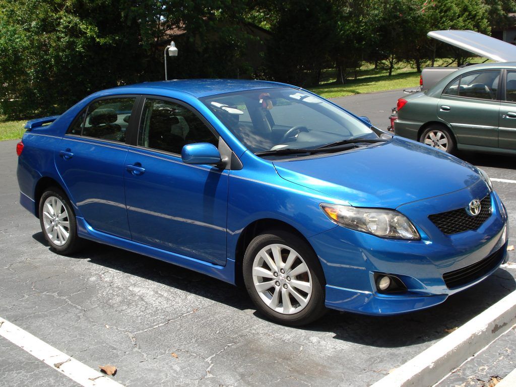 A blue toyota car is parked in a parking lot