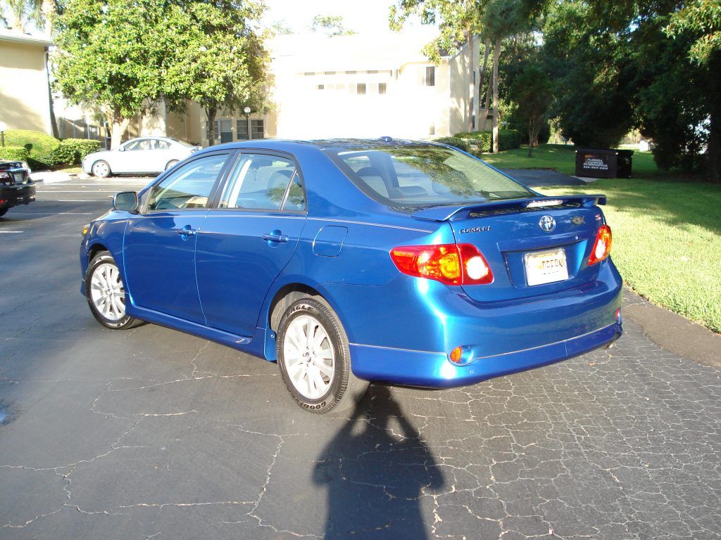 A blue toyota corolla is parked in a driveway