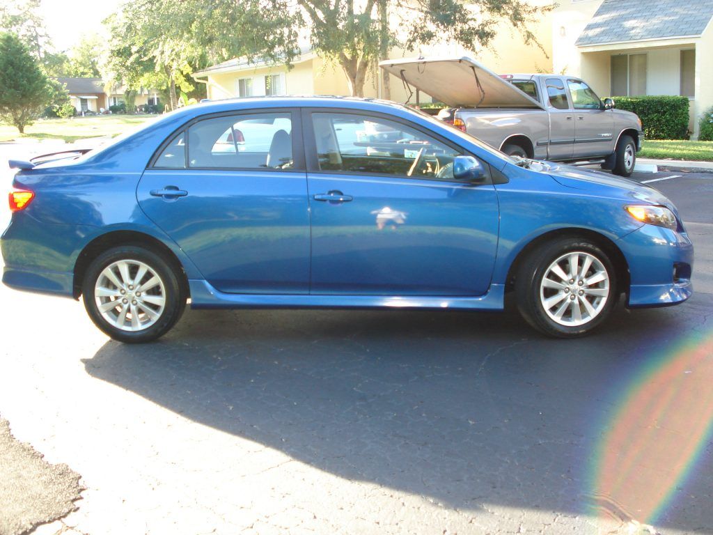 A blue car is parked on the side of the road