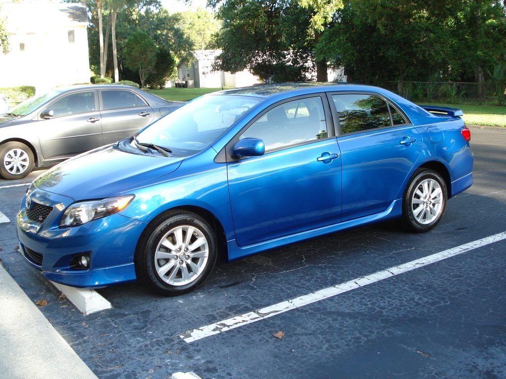 A blue car is parked in a parking lot