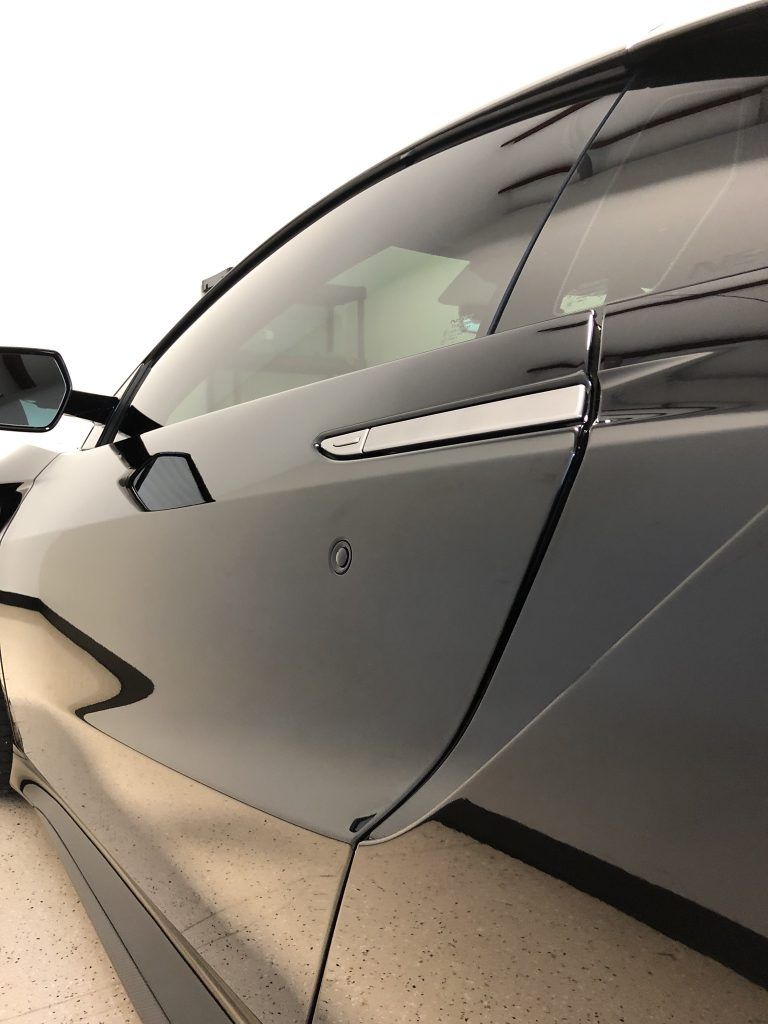 A car is parked in a garage with the door open