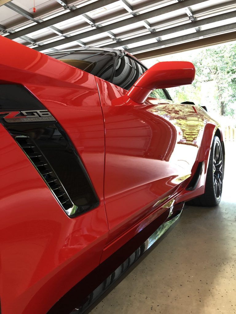 A red sports car is parked in a garage.