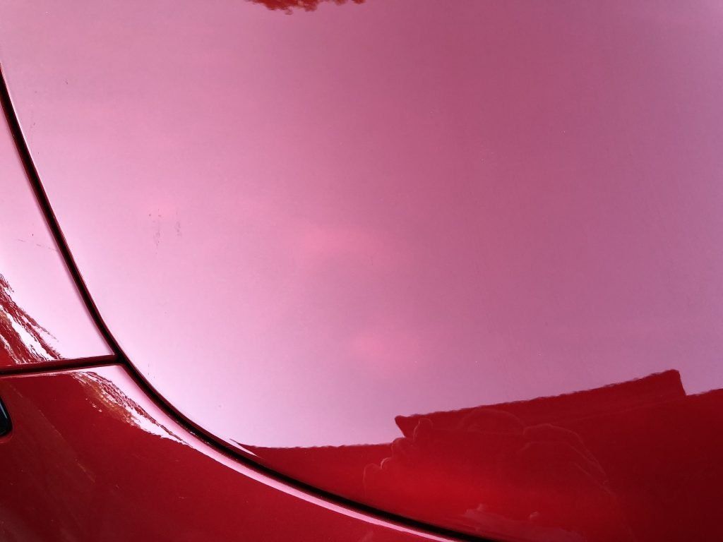 A close up of the hood of a red car