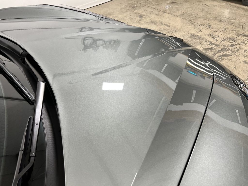 A close up of the hood of a car in a garage.