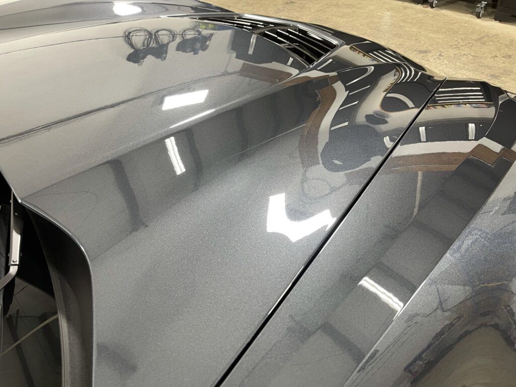 A close up of the hood of a car in a garage.