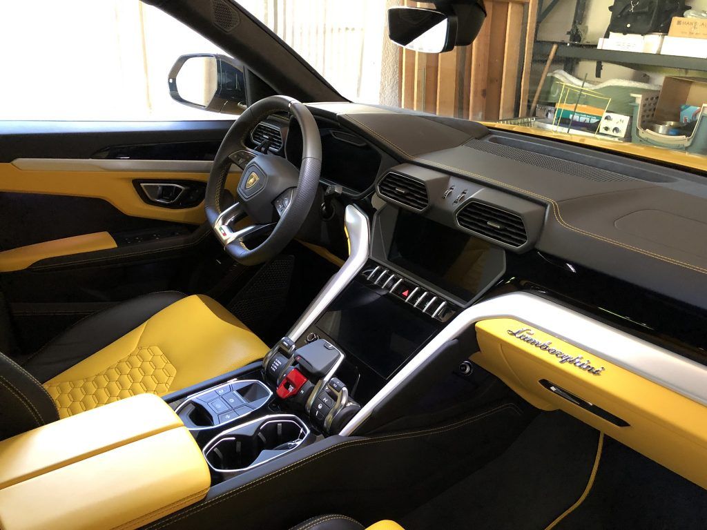 The interior of a lamborghini urus is shown in a garage.